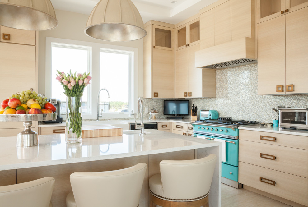 Design ideas for a mid-sized beach style l-shaped open plan kitchen in Other with a farmhouse sink, flat-panel cabinets, light wood cabinets, beige splashback, coloured appliances, with island and beige floor.