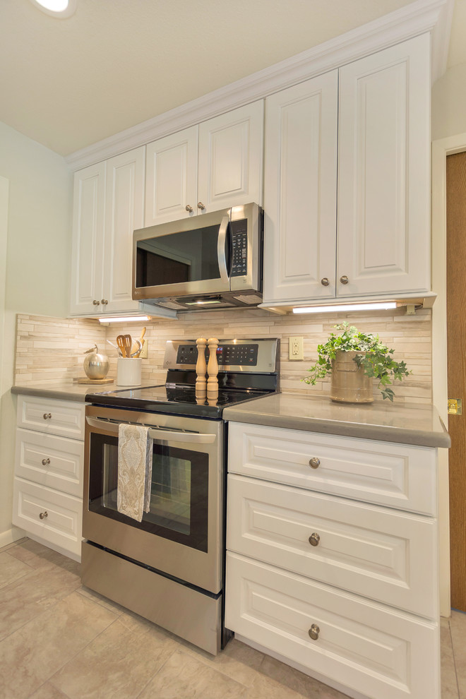 Inspiration for a large transitional l-shaped porcelain tile open concept kitchen remodel in Phoenix with an undermount sink, raised-panel cabinets, white cabinets, quartz countertops, beige backsplash, porcelain backsplash, stainless steel appliances and an island