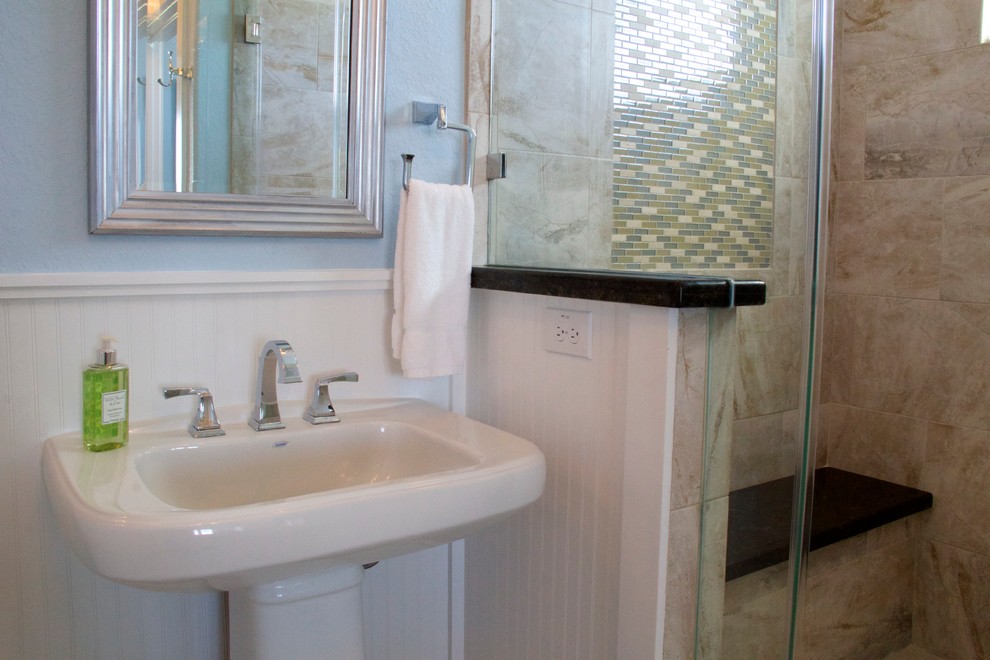 This is an example of a mid-sized beach style 3/4 bathroom in Houston with a pedestal sink, an alcove shower, travertine floors, beige tile, porcelain tile and blue walls.