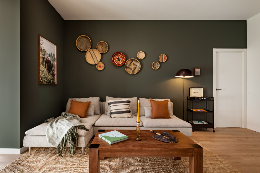 Ejemplo de salón tropical con paredes verdes, suelo de madera en tonos medios y suelo marrón