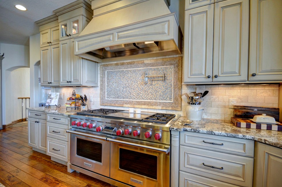 Example of a mid-sized transitional medium tone wood floor eat-in kitchen design in Denver with an undermount sink, furniture-like cabinets, black cabinets, laminate countertops, beige backsplash, subway tile backsplash, stainless steel appliances and beige walls