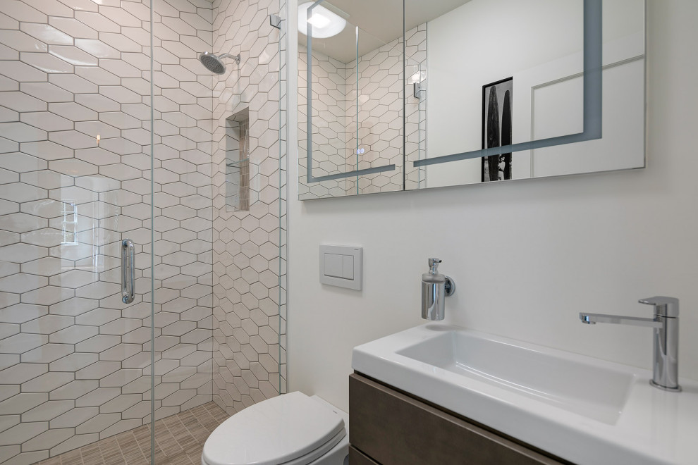 Design ideas for a small transitional kids bathroom in San Francisco with flat-panel cabinets, brown cabinets, an alcove shower, a wall-mount toilet, white tile, ceramic tile, white walls, porcelain floors, an integrated sink, beige floor, a hinged shower door and white benchtops.
