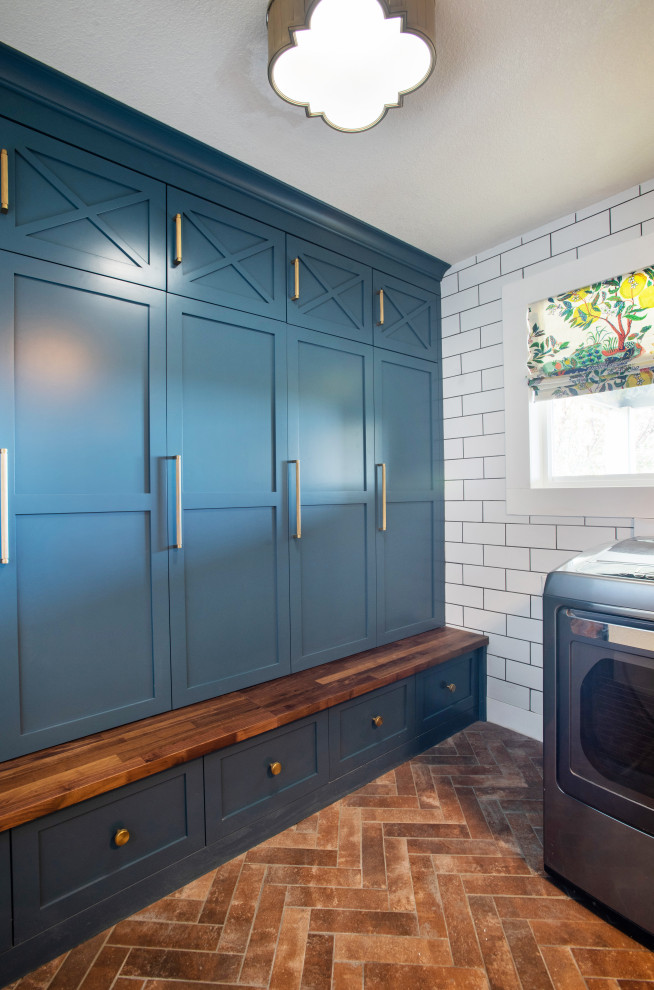 Design ideas for a small transitional utility room in Denver with shaker cabinets, blue cabinets, wood benchtops, white walls, brick floors, a side-by-side washer and dryer, red floor and brown benchtop.