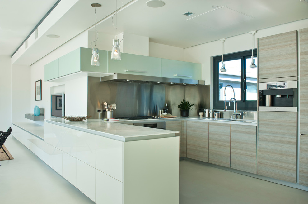 Contemporary u-shaped kitchen in San Francisco with flat-panel cabinets, light wood cabinets and stainless steel appliances.