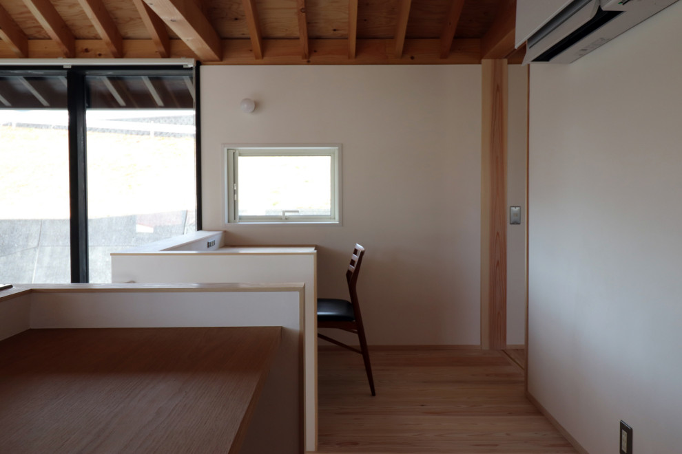 Cette image montre un petit bureau avec un mur blanc, parquet clair, aucune cheminée, un bureau intégré, un sol blanc, poutres apparentes et du lambris de bois.