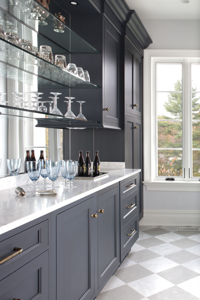 Large transitional l-shaped kitchen pantry in New York with beaded inset cabinets, grey cabinets, marble benchtops, mirror splashback and porcelain floors.