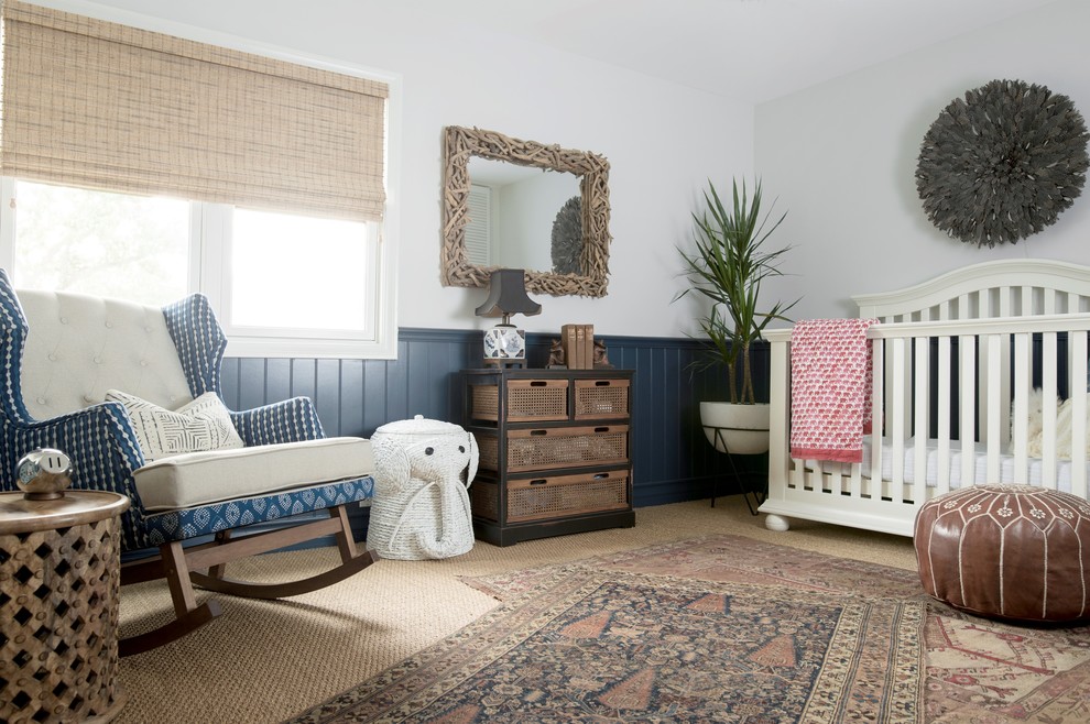 This is an example of a beach style gender-neutral nursery in Orange County with blue walls, carpet and beige floor.