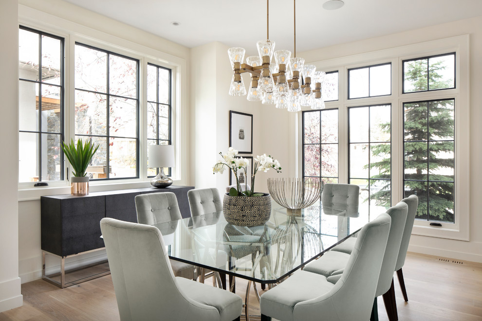 Design ideas for a transitional dining room in Calgary with white walls and light hardwood floors.