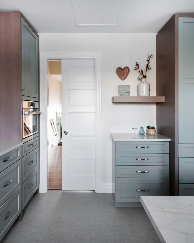 Example of a mid-sized transitional u-shaped linoleum floor and gray floor eat-in kitchen design in Ottawa with a farmhouse sink, shaker cabinets, gray cabinets, quartz countertops, white backsplash, subway tile backsplash, stainless steel appliances, an island and white countertops