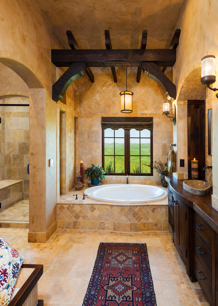 Design ideas for a master bathroom in Other with dark wood cabinets, a drop-in tub, an alcove shower, beige tile, beige walls, a vessel sink, beige floor, a hinged shower door and flat-panel cabinets.