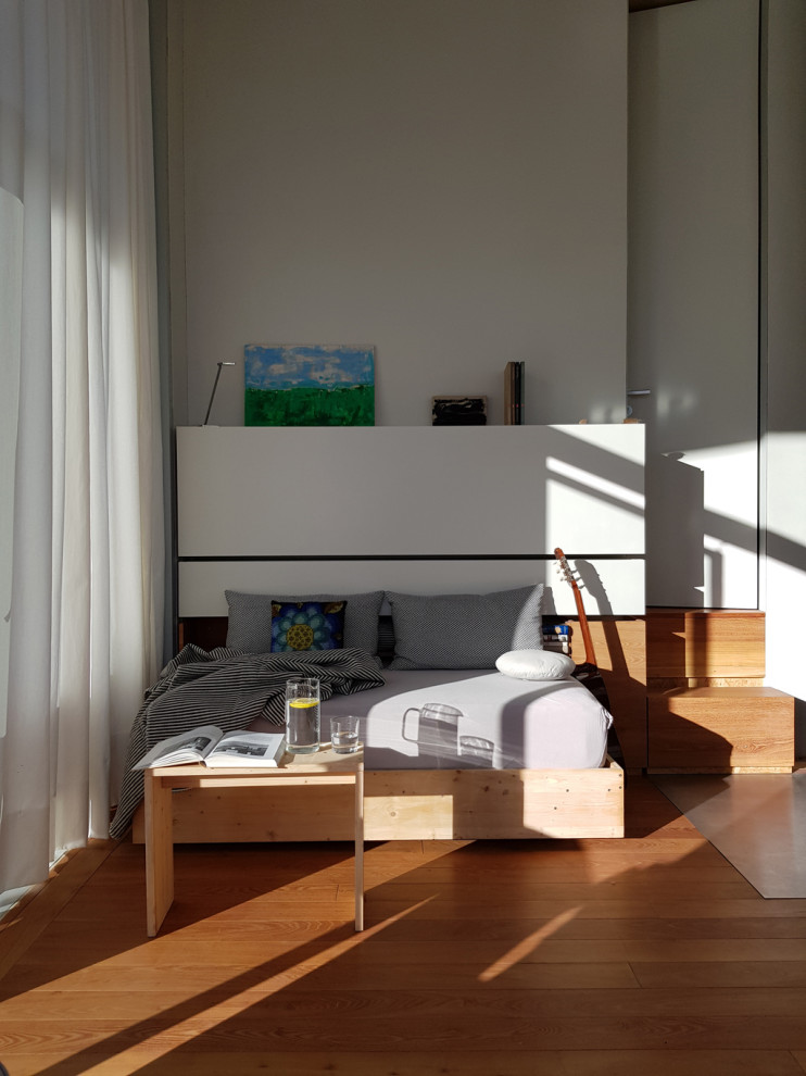 Идея дизайна: маленькая спальня в стиле модернизм с серыми стенами, светлым паркетным полом и коричневым полом для на участке и в саду