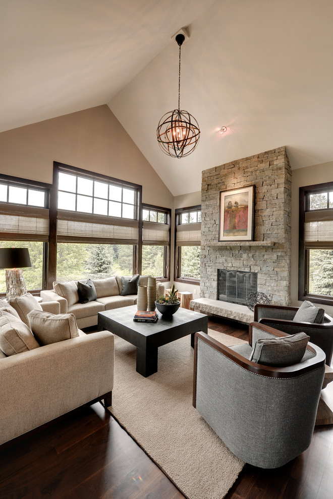 Photo of a transitional family room in Minneapolis with beige walls, dark hardwood floors, a standard fireplace and a stone fireplace surround.