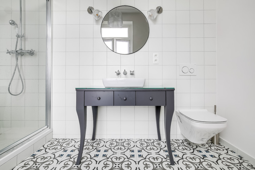 Inspiration for a mid-sized midcentury master bathroom in Paris with an alcove tub, an alcove shower, a wall-mount toilet, white tile, cement tile, white walls, cement tiles, a drop-in sink, blue floor, a hinged shower door and glass benchtops.