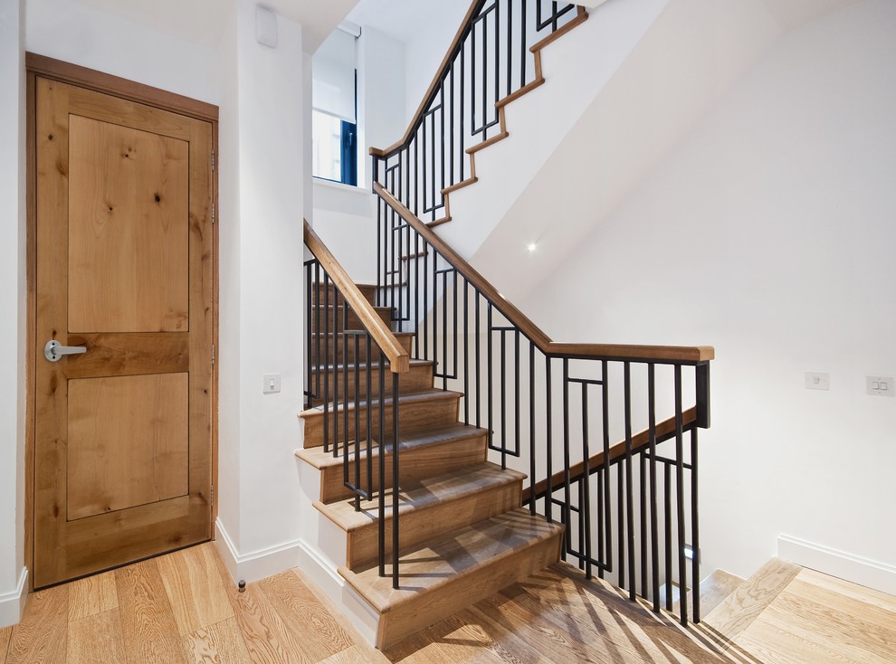 This is an example of a mid-sized country wood l-shaped staircase in Vancouver with wood risers and metal railing.