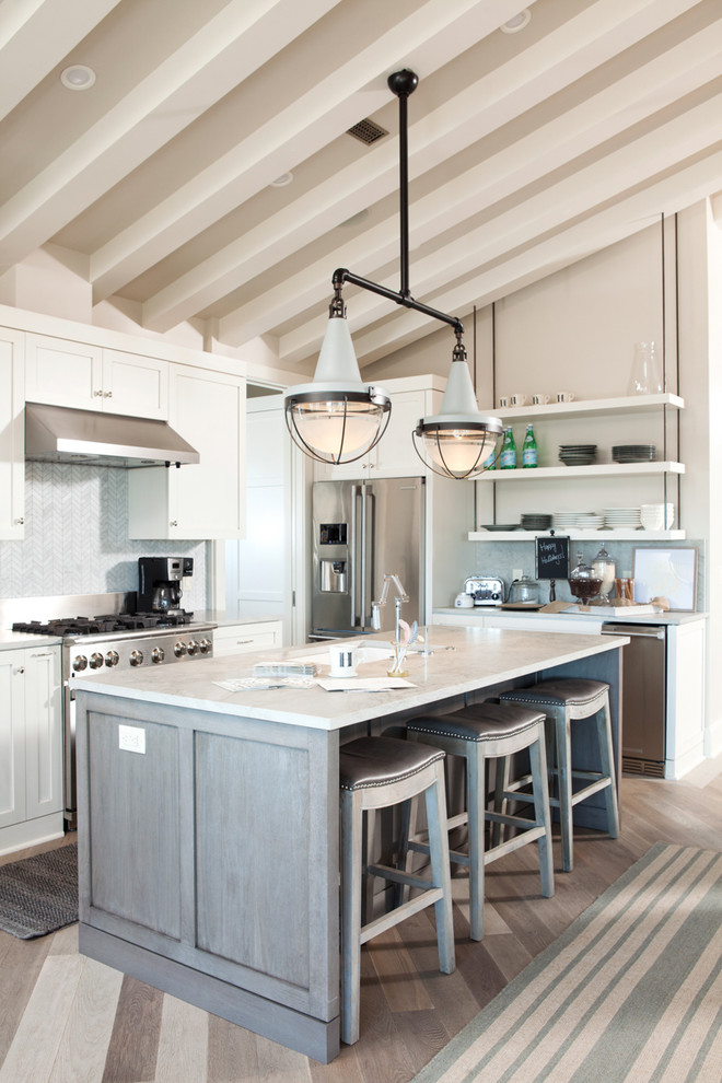 Large beach style eat-in kitchen in Other with light hardwood floors, with island and an undermount sink.