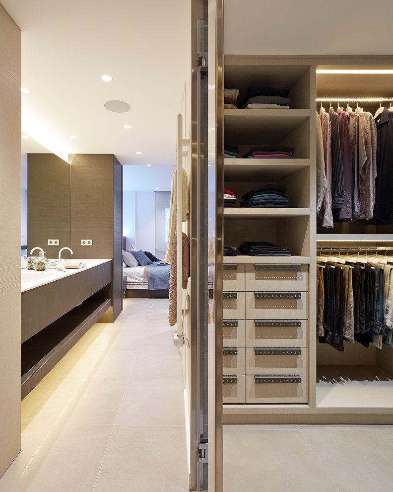Photo of a mid-sized contemporary men's dressing room in Barcelona with flat-panel cabinets, ceramic floors and beige cabinets.