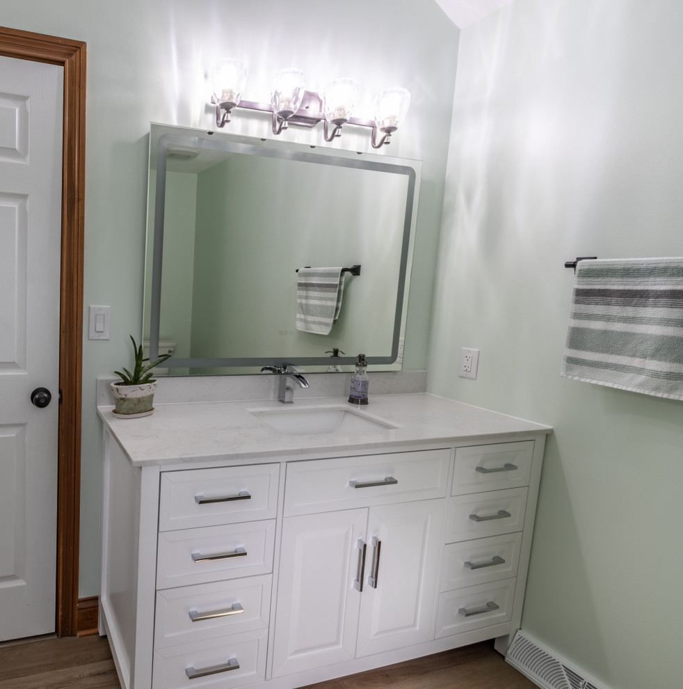 Inspiration for a contemporary white tile and ceramic tile vinyl floor, brown floor and double-sink bathroom remodel in Cleveland with shaker cabinets, white cabinets, a two-piece toilet, green walls, an undermount sink, quartz countertops, a hinged shower door, white countertops and a freestanding vanity