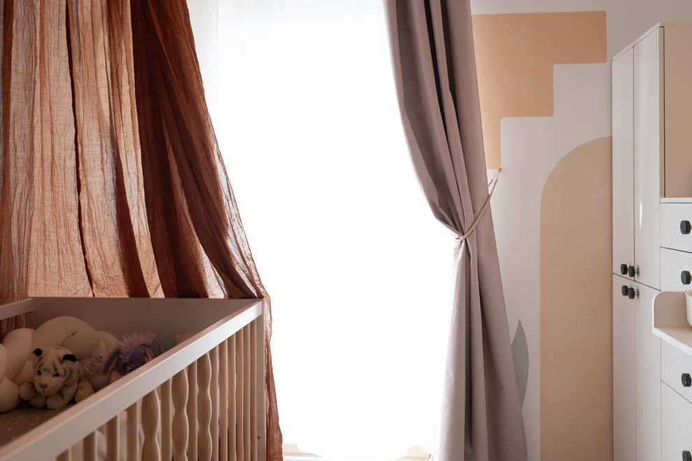 Imagen de habitación de bebé neutra actual pequeña con parades naranjas, suelo de madera clara, suelo beige, papel pintado y papel pintado