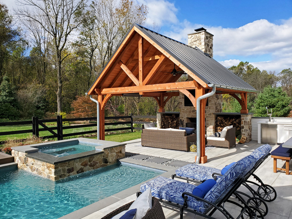 Design ideas for a large country backyard custom-shaped pool in Philadelphia with concrete pavers and a hot tub.