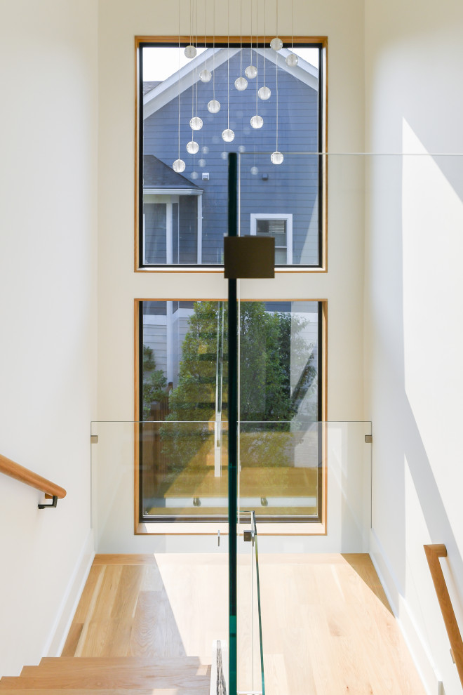 Large contemporary wood floating glass railing staircase in DC Metro with open risers.
