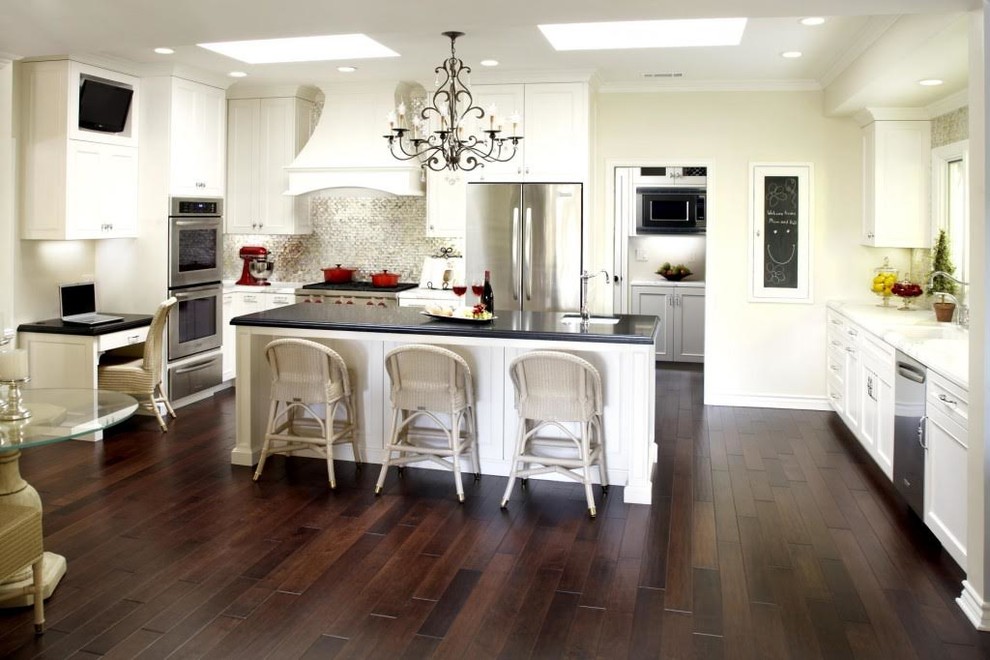 Mid-sized transitional l-shaped dark wood floor and brown floor eat-in kitchen photo with an undermount sink, recessed-panel cabinets, white cabinets, marble countertops, metallic backsplash, mosaic tile backsplash, stainless steel appliances and an island