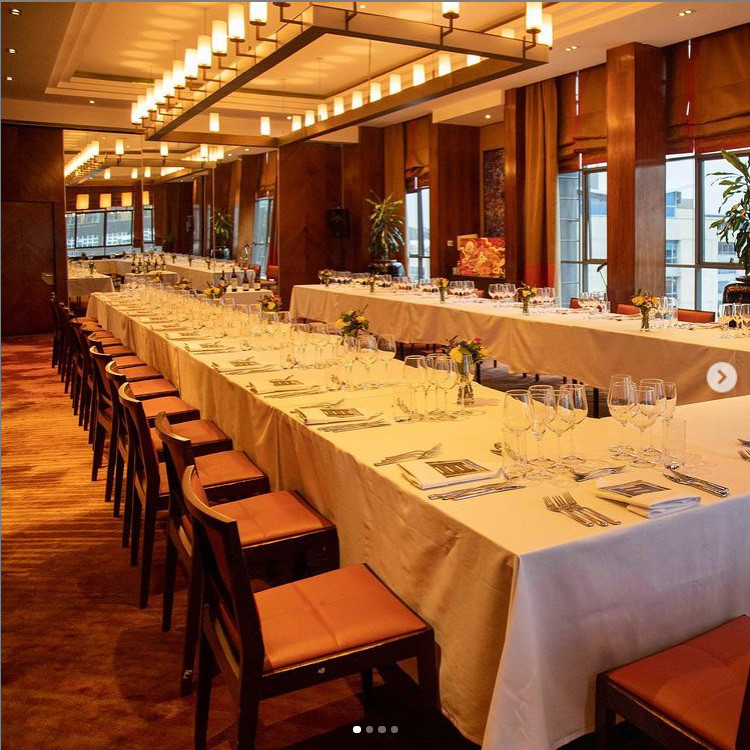 Example of a transitional carpeted, brown floor, tray ceiling and wall paneling dining room design