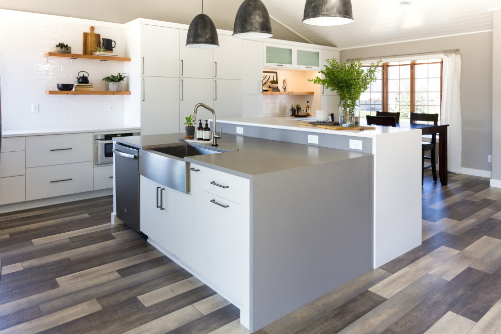 Inspiration for a large industrial l-shaped open plan kitchen in Other with an undermount sink, white cabinets, quartz benchtops, stainless steel appliances, light hardwood floors, with island, multi-coloured floor and white benchtop.