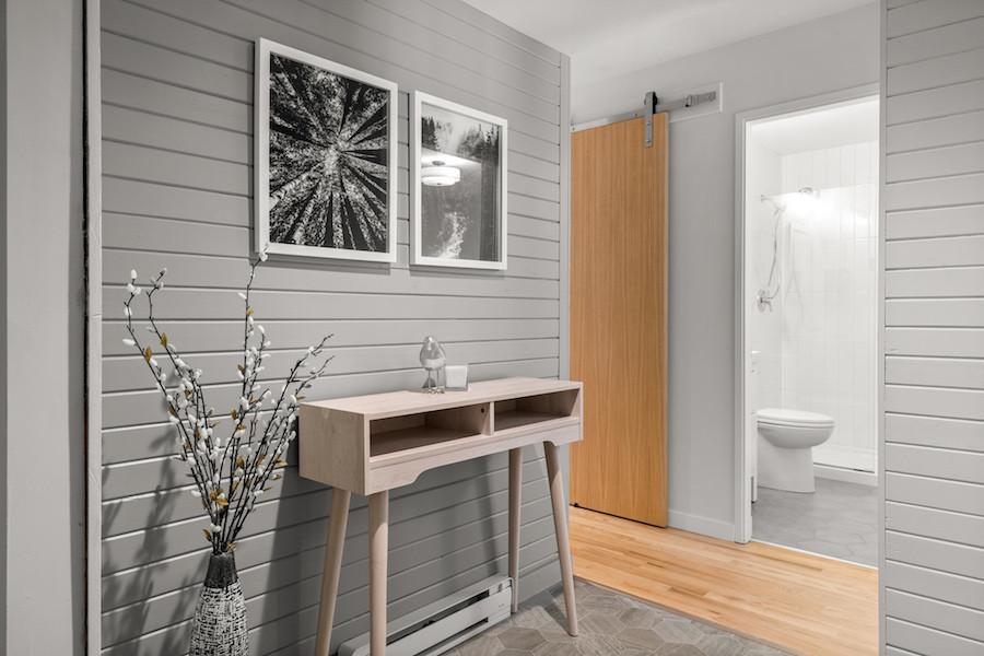 Front door - small transitional laminate floor, gray floor and wall paneling front door idea with gray walls
