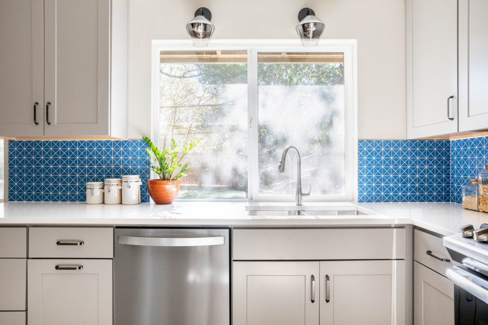 Enclosed kitchen - mid-sized transitional u-shaped terrazzo floor and multicolored floor enclosed kitchen idea in Austin with a double-bowl sink, shaker cabinets, gray cabinets, quartz countertops, blue backsplash, ceramic backsplash, stainless steel appliances, no island and white countertops