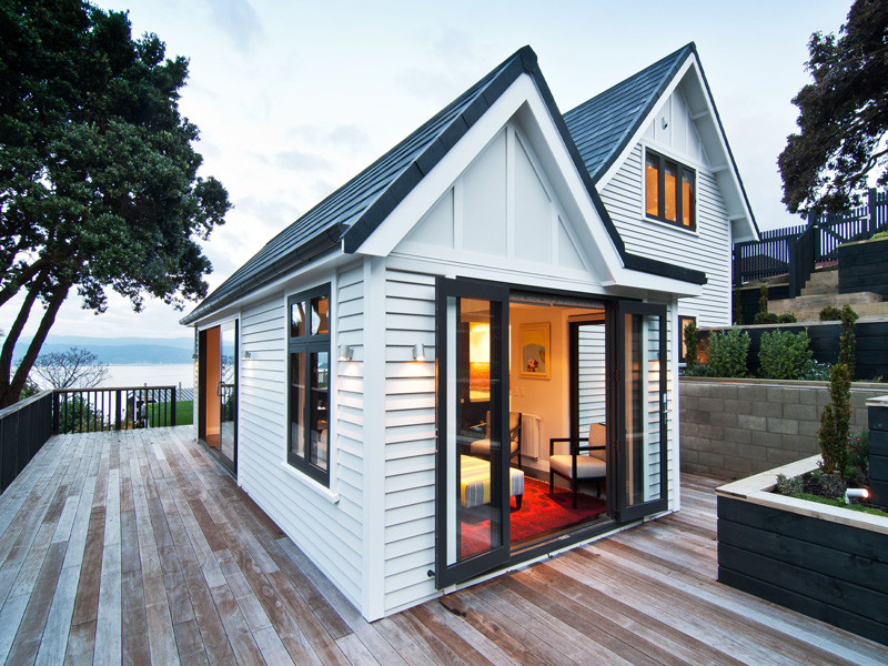 Inspiration for a large transitional two-storey white exterior in Wellington with wood siding.