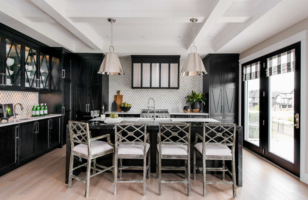 This is an example of a transitional l-shaped kitchen in New York with an undermount sink, shaker cabinets, black cabinets, white splashback, mosaic tile splashback, panelled appliances, light hardwood floors and with island.
