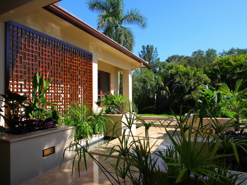 This is an example of an asian front yard patio in Tampa with a water feature.