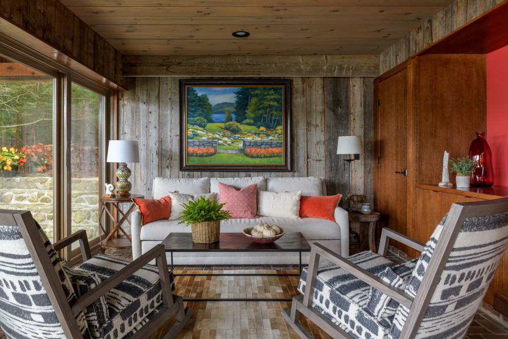 На фото: гостиная комната в стиле рустика с красными стенами, деревянным потолком и деревянными стенами с