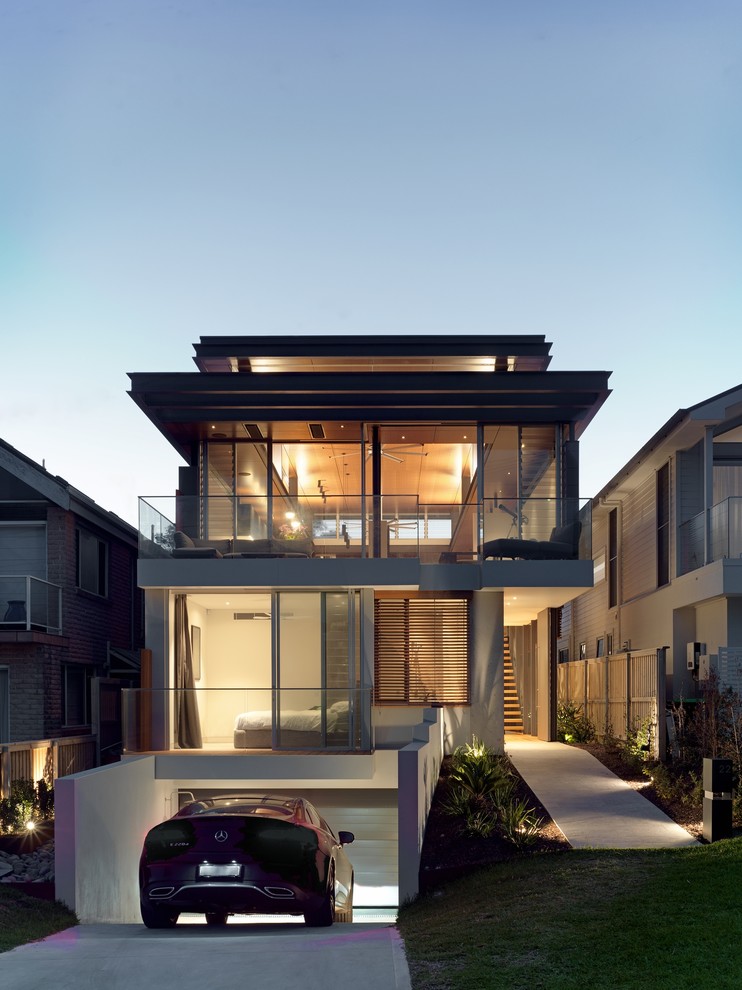 This is an example of a contemporary two-storey glass grey house exterior in Sydney with a flat roof.