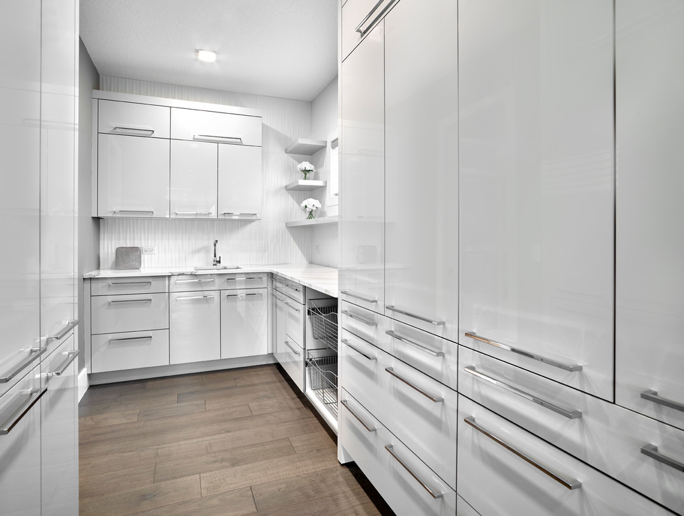 Large contemporary gender-neutral walk-in wardrobe in Edmonton with louvered cabinets, white cabinets, porcelain floors and grey floor.