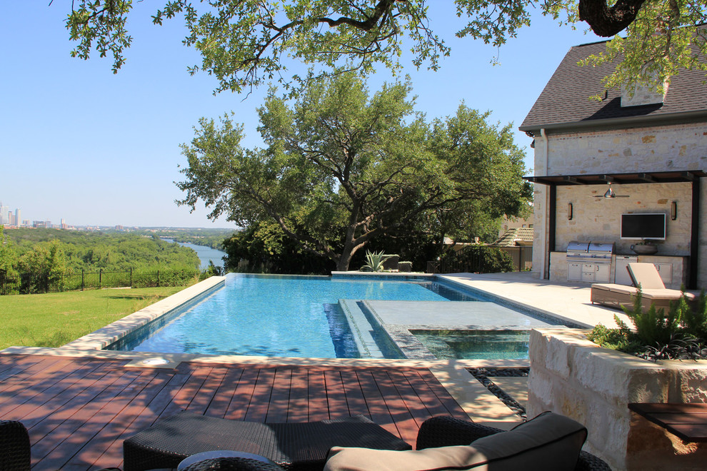 Photo of a large contemporary backyard l-shaped lap pool in Austin with a hot tub and concrete pavers.