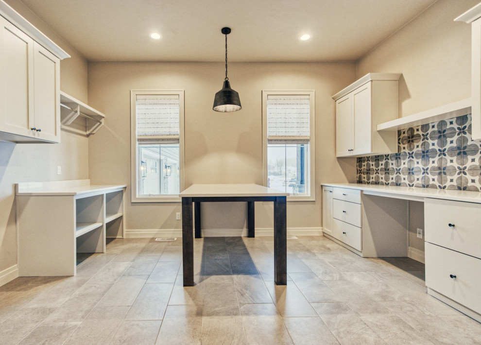 Example of a large transitional u-shaped ceramic tile and gray floor utility room design with an undermount sink, shaker cabinets, white cabinets, quartz countertops, gray walls, a side-by-side washer/dryer and white countertops