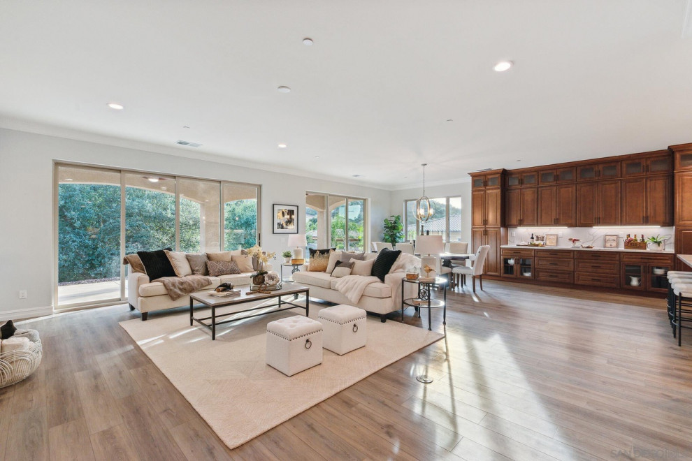 Esempio di un ampio soggiorno design con pareti bianche, pavimento in legno massello medio e pavimento marrone