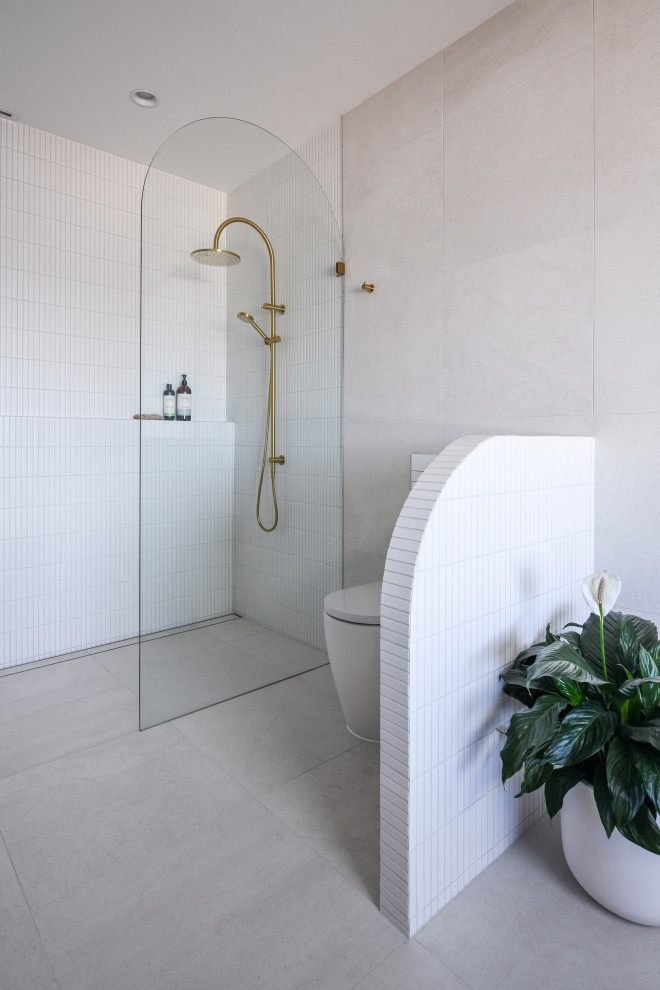 Photo of an expansive beach style master bathroom in Sydney with medium wood cabinets, a freestanding tub, a double shower, a wall-mount toilet, yellow tile, porcelain tile, white walls, porcelain floors, a drop-in sink, engineered quartz benchtops, white floor, an open shower, a niche, a double vanity and a floating vanity.