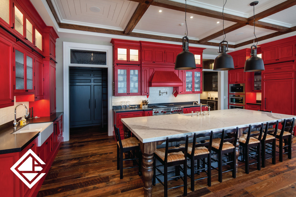 Inspiration for a huge rustic l-shaped medium tone wood floor kitchen remodel with a farmhouse sink, raised-panel cabinets, red cabinets, granite countertops, white backsplash and an island