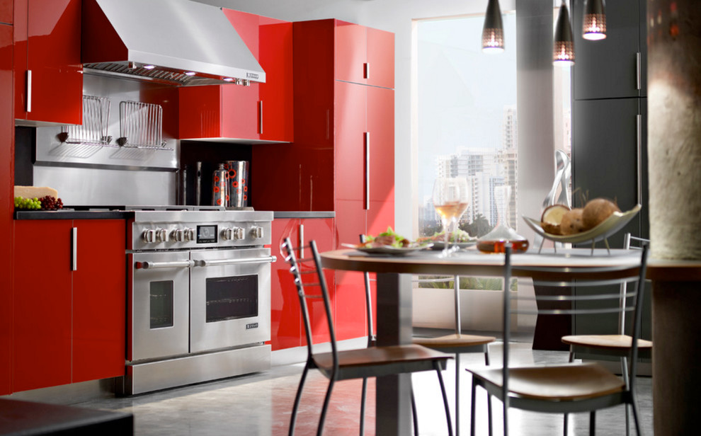 Mid-sized contemporary l-shaped eat-in kitchen in Vancouver with flat-panel cabinets, red cabinets, solid surface benchtops, stainless steel appliances, concrete floors, no island and grey floor.