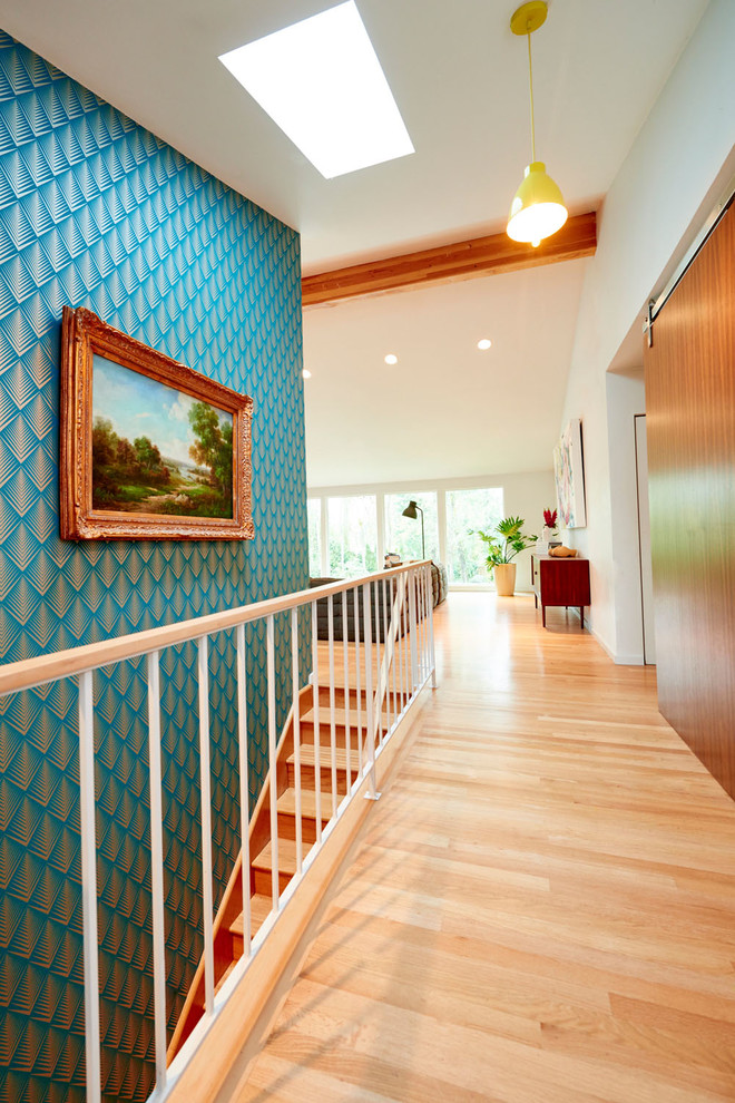 This is an example of a large midcentury hallway in Portland with white walls, light hardwood floors and beige floor.