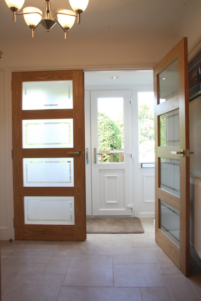 Foto di un ingresso o corridoio chic di medie dimensioni con pareti bianche, pavimento in travertino, una porta a due ante, una porta bianca e pavimento beige