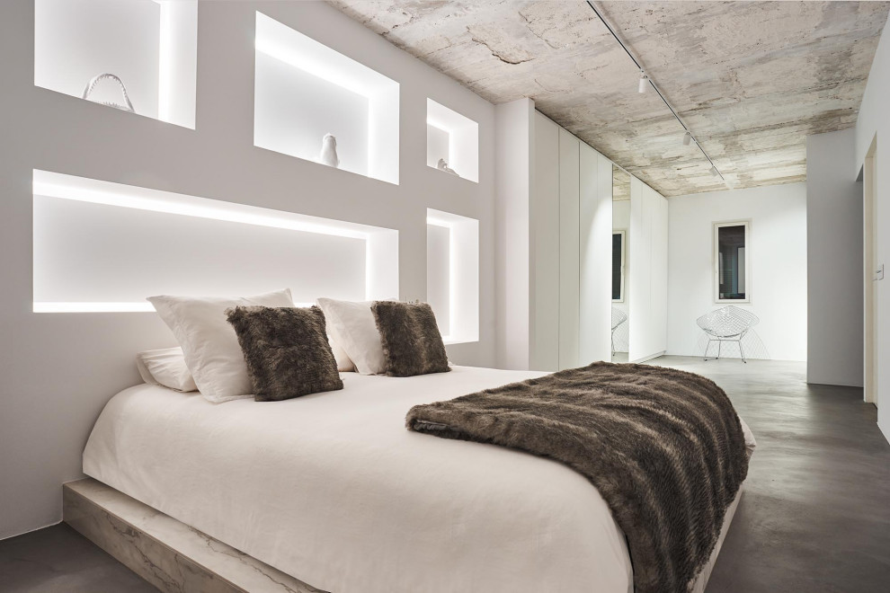 Ejemplo de dormitorio moderno con paredes blancas, suelo de cemento y suelo gris
