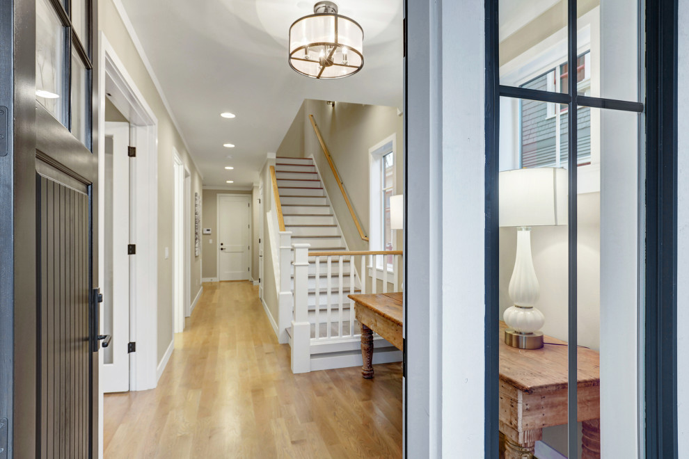 Foyer - contemporary light wood floor foyer idea in Seattle with a black front door