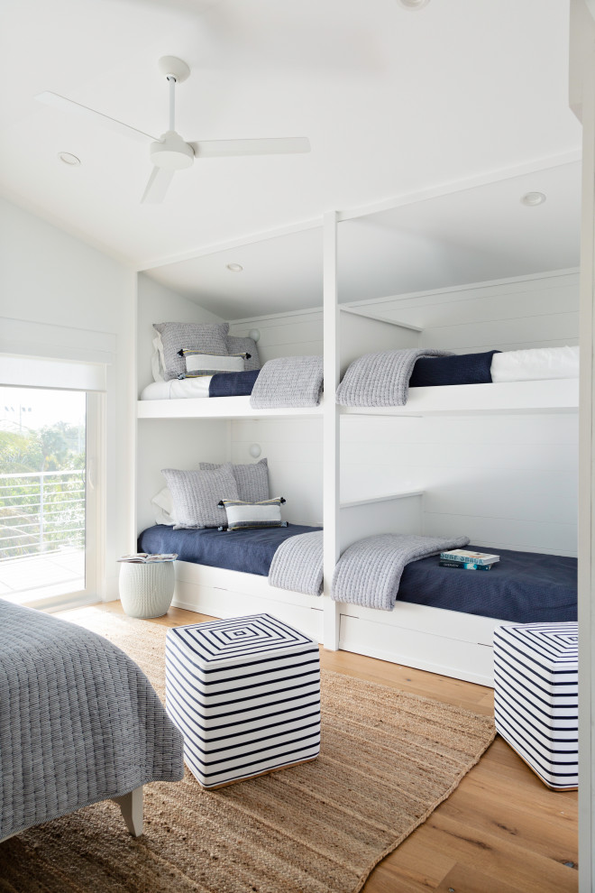 Inspiration for a large beach style gender-neutral kids' bedroom for kids 4-10 years old in Tampa with white walls, medium hardwood floors and beige floor.