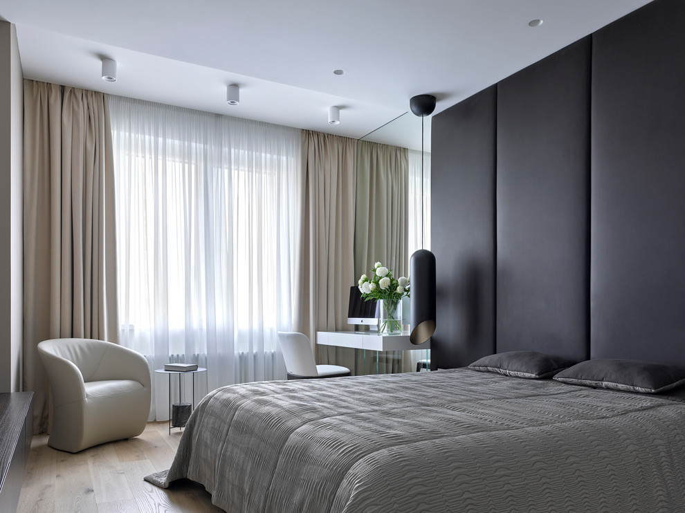 Contemporary master bedroom in Moscow with no fireplace and light hardwood floors.