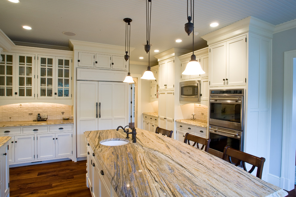 Example of a huge transitional u-shaped dark wood floor and brown floor enclosed kitchen design in Burlington with an undermount sink, shaker cabinets, white cabinets, marble countertops, beige backsplash, stone tile backsplash, stainless steel appliances and an island