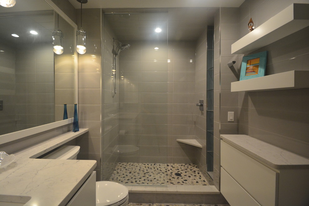 Small modern master bathroom in Milwaukee with flat-panel cabinets, white cabinets, an alcove shower, a two-piece toilet, gray tile, porcelain tile, grey walls, pebble tile floors, an undermount sink, granite benchtops, multi-coloured floor, an open shower and white benchtops.