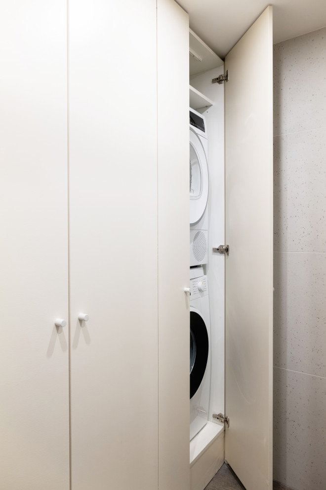 Small single-wall utility room in Paris with an integrated sink, beaded inset cabinets, beige cabinets, beige walls, ceramic floors, a concealed washer and dryer and brown floor.